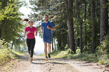 Image showing couple enjoying in a healthy lifestyle while jogging on a country road