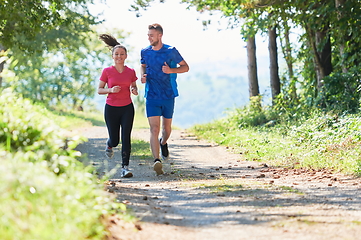 Image showing couple enjoying in a healthy lifestyle while jogging on a country road