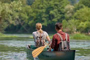 Image showing friends are canoeing in a wild river