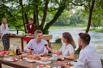 Image showing friends having picnic french dinner party outdoor during summer holiday