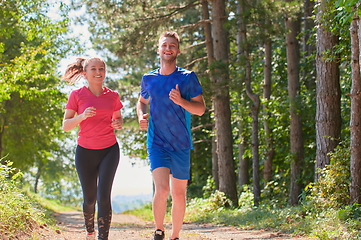 Image showing couple enjoying in a healthy lifestyle while jogging on a country road