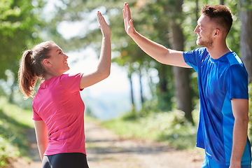 Image showing couple enjoying in a healthy lifestyle while jogging on a country road