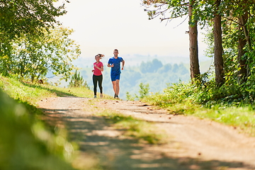 Image showing couple enjoying in a healthy lifestyle while jogging on a country road