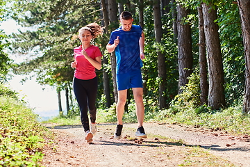 Image showing couple enjoying in a healthy lifestyle while jogging on a country road