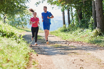 Image showing couple enjoying in a healthy lifestyle while jogging on a country road