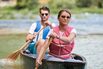 Image showing friends are canoeing in a wild river