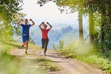 Image showing couple enjoying in a healthy lifestyle while jogging on a country road