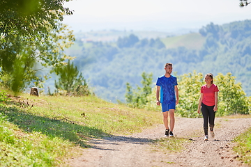 Image showing couple enjoying in a healthy lifestyle while jogging on a country road