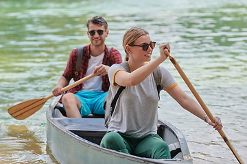 Image showing friends are canoeing in a wild river