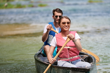 Image showing friends are canoeing in a wild river