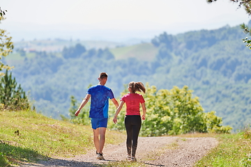 Image showing couple enjoying in a healthy lifestyle while jogging on a country road