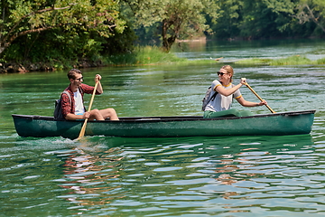 Image showing friends are canoeing in a wild river