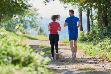 Image showing couple enjoying in a healthy lifestyle while jogging on a country road