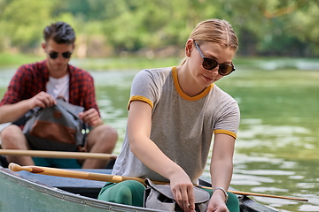 Image showing friends are canoeing in a wild river