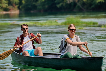 Image showing friends are canoeing in a wild river