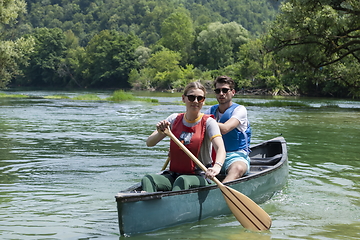 Image showing friends are canoeing in a wild river