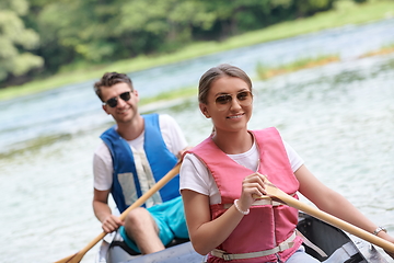 Image showing friends are canoeing in a wild river