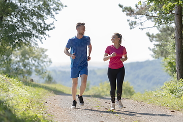 Image showing couple enjoying in a healthy lifestyle while jogging on a country road