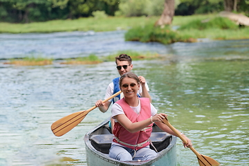 Image showing friends are canoeing in a wild river