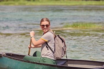 Image showing woman adventurous explorer are canoeing in a wild river