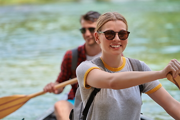 Image showing friends are canoeing in a wild river