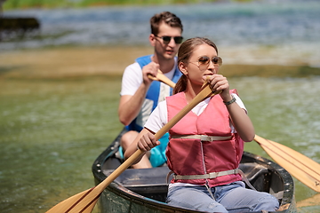 Image showing friends are canoeing in a wild river