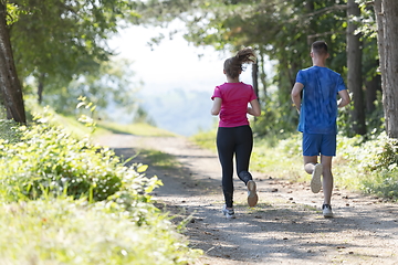 Image showing couple enjoying in a healthy lifestyle while jogging on a country road