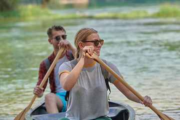 Image showing friends are canoeing in a wild river