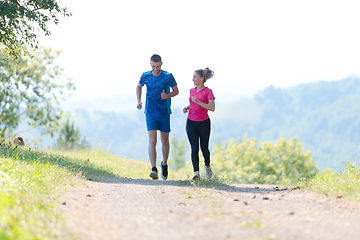 Image showing couple enjoying in a healthy lifestyle while jogging on a country road