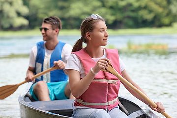 Image showing friends are canoeing in a wild river