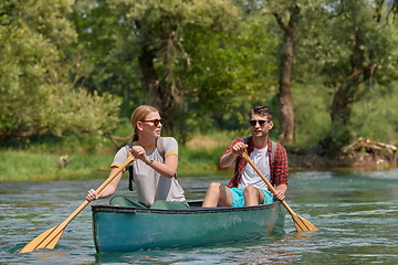 Image showing friends are canoeing in a wild river