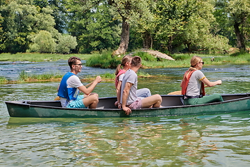 Image showing Group adventurous explorer friends are canoeing in a wild river