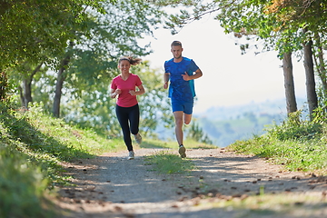 Image showing couple enjoying in a healthy lifestyle while jogging on a country road