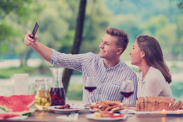 Image showing couple taking selfie while having picnic french dinner party outdoor