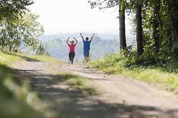 Image showing couple enjoying in a healthy lifestyle while jogging on a country road