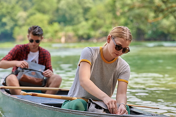 Image showing friends are canoeing in a wild river