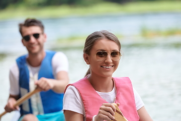 Image showing friends are canoeing in a wild river