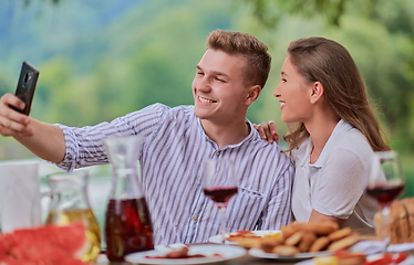 Image showing couple taking selfie while having picnic french dinner party outdoor
