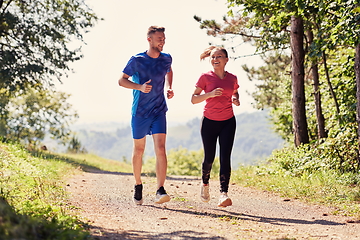 Image showing couple enjoying in a healthy lifestyle while jogging on a country road