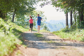 Image showing couple enjoying in a healthy lifestyle while jogging on a country road