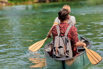 Image showing friends are canoeing in a wild river