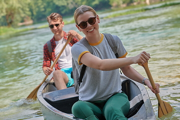 Image showing friends are canoeing in a wild river