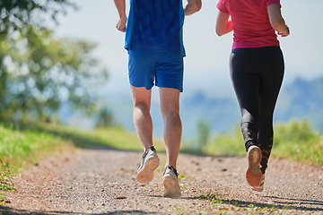 Image showing couple enjoying in a healthy lifestyle while jogging on a country road