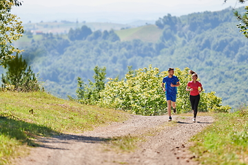 Image showing couple enjoying in a healthy lifestyle while jogging on a country road