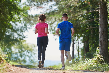 Image showing couple enjoying in a healthy lifestyle while jogging on a country road