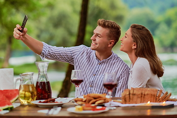 Image showing couple taking selfie while having picnic french dinner party outdoor