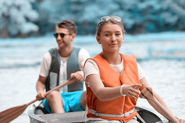 Image showing friends are canoeing in a wild river