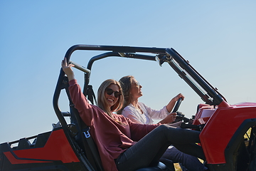 Image showing girls enjoying a beautiful sunny day while driving an off-road car