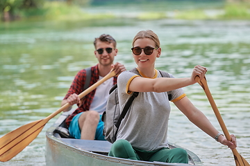 Image showing friends are canoeing in a wild river