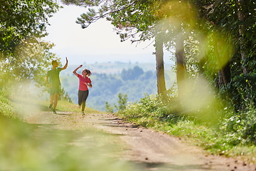 Image showing couple enjoying in a healthy lifestyle while jogging on a country road